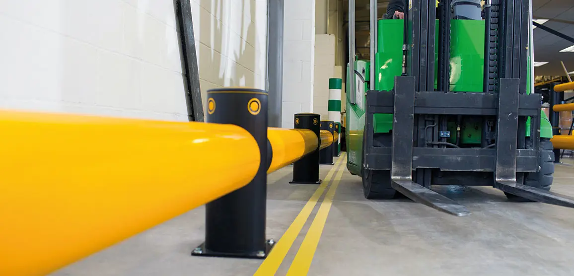 Barrera de protección para estanterías RackEnd® instalada en un pasillo logístico para proteger los racks industriales de impactos de montacargas.